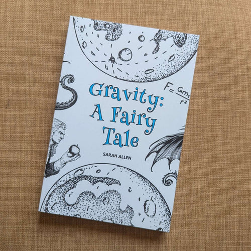the gravity: a fairy tale paperback sitting on a piece of furniture