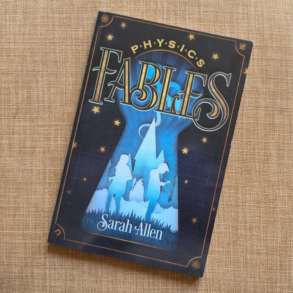 the paperback of Physics Fables sitting on  fabric