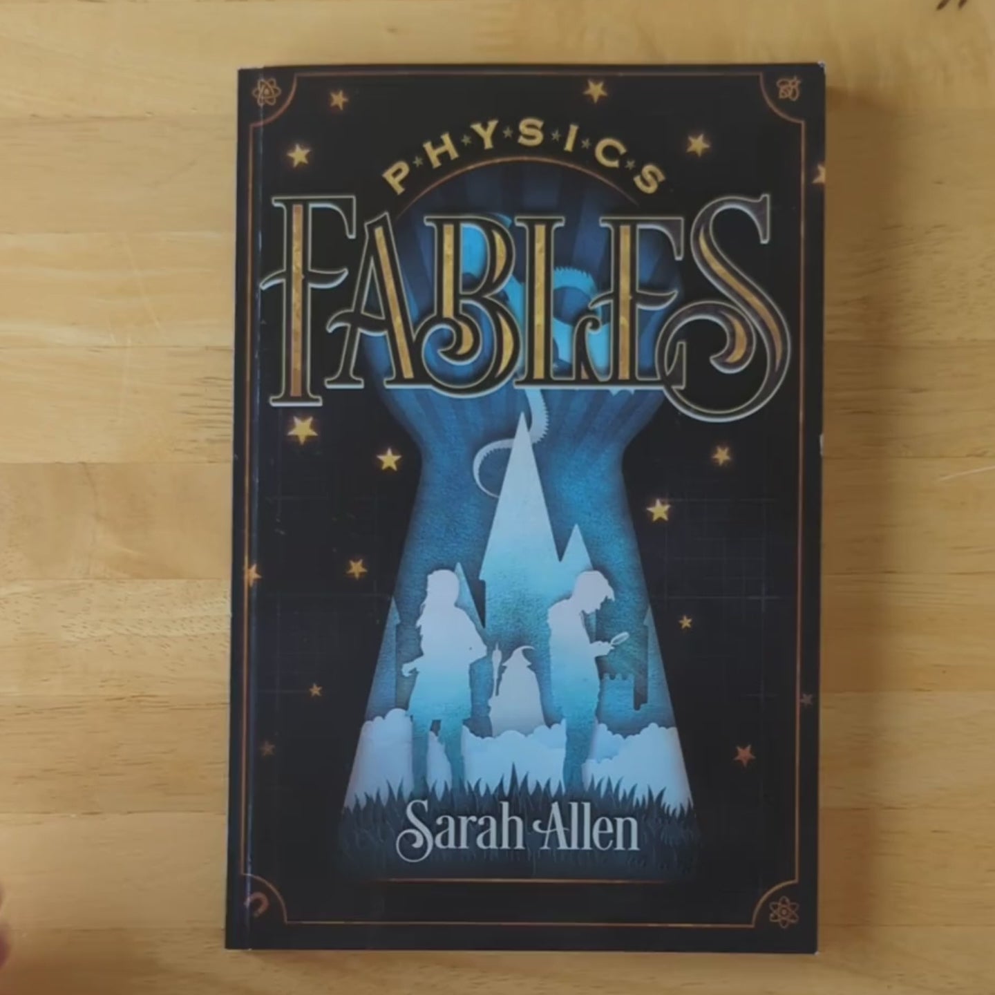 a video of hands flipping through physics fables, showing color illustrations