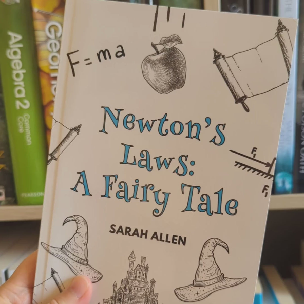 a video of the newton's laws paperback rotating in front of a bookshelf. The spine is about a third of an inch thick